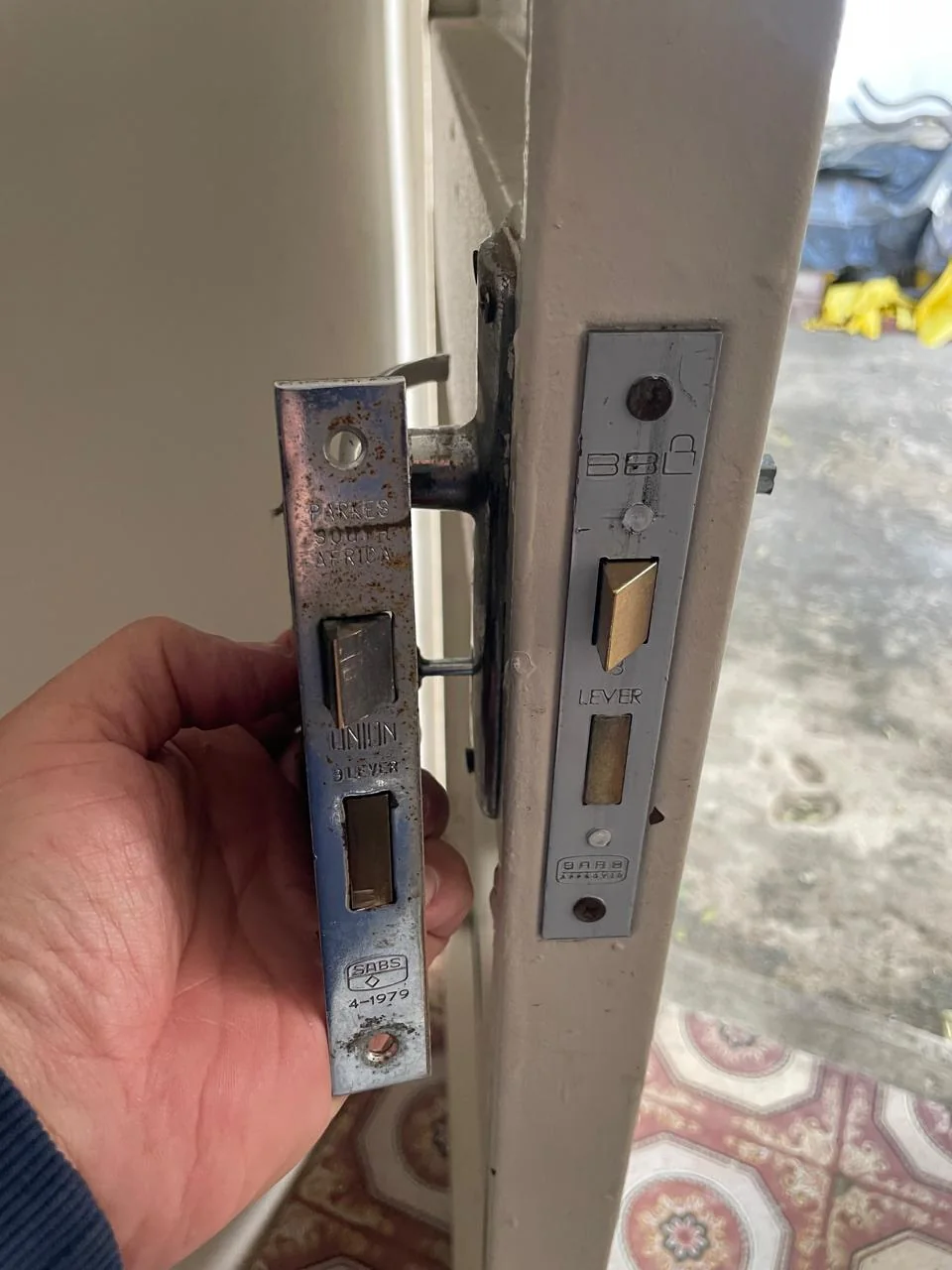 A removed lock mechanism alongside the edge of the door